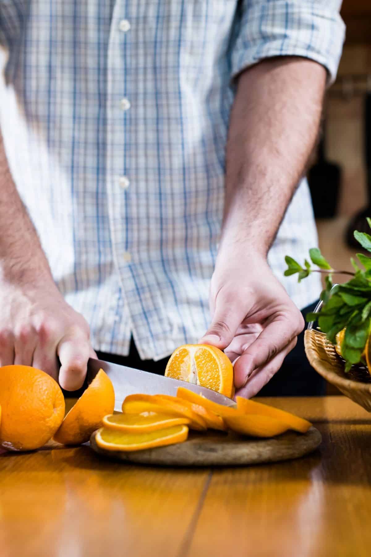 hombre cortando una naranja.