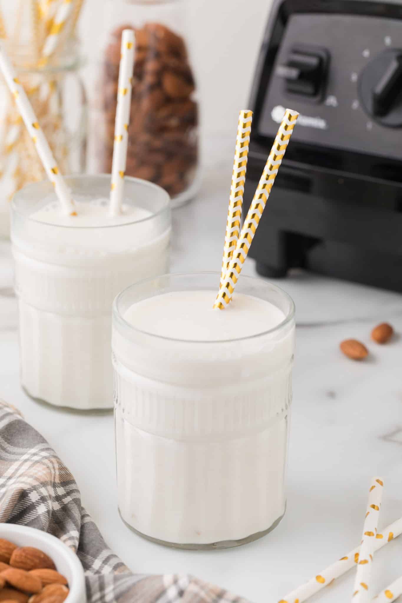 dos vasos de leche de almendras casera con pajitas.