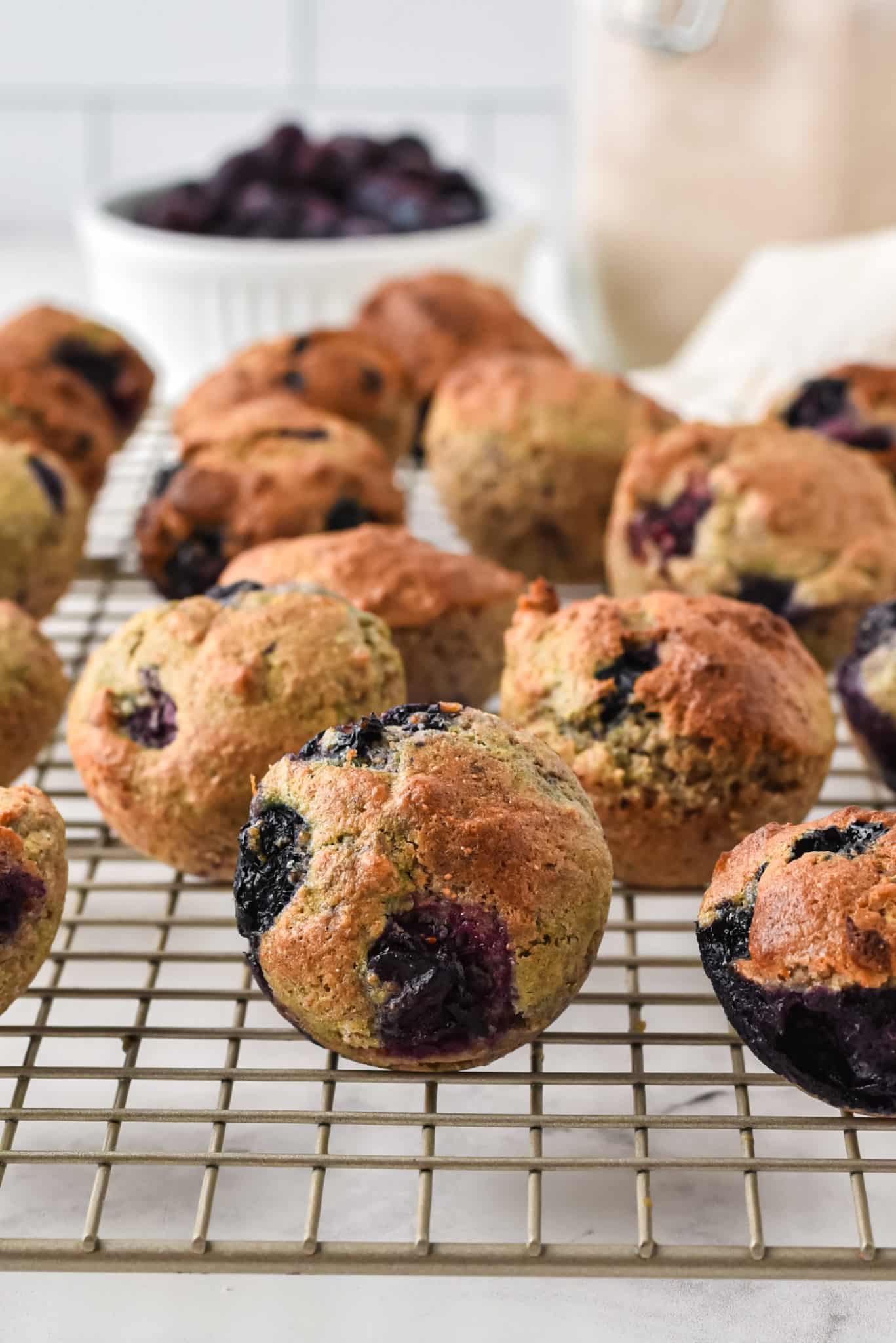 Minimuffins de arándanos azules colocados en una rejilla para enfriar.