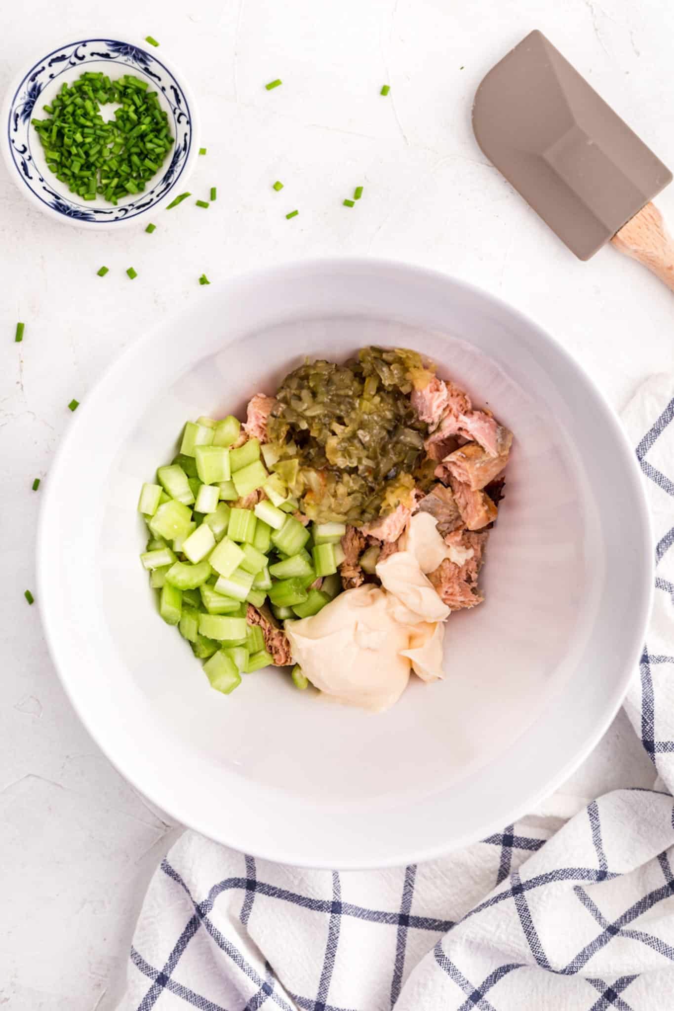 Ingredientes de ensalada de salmón cortado en cubitos en un tazón blanco grande.