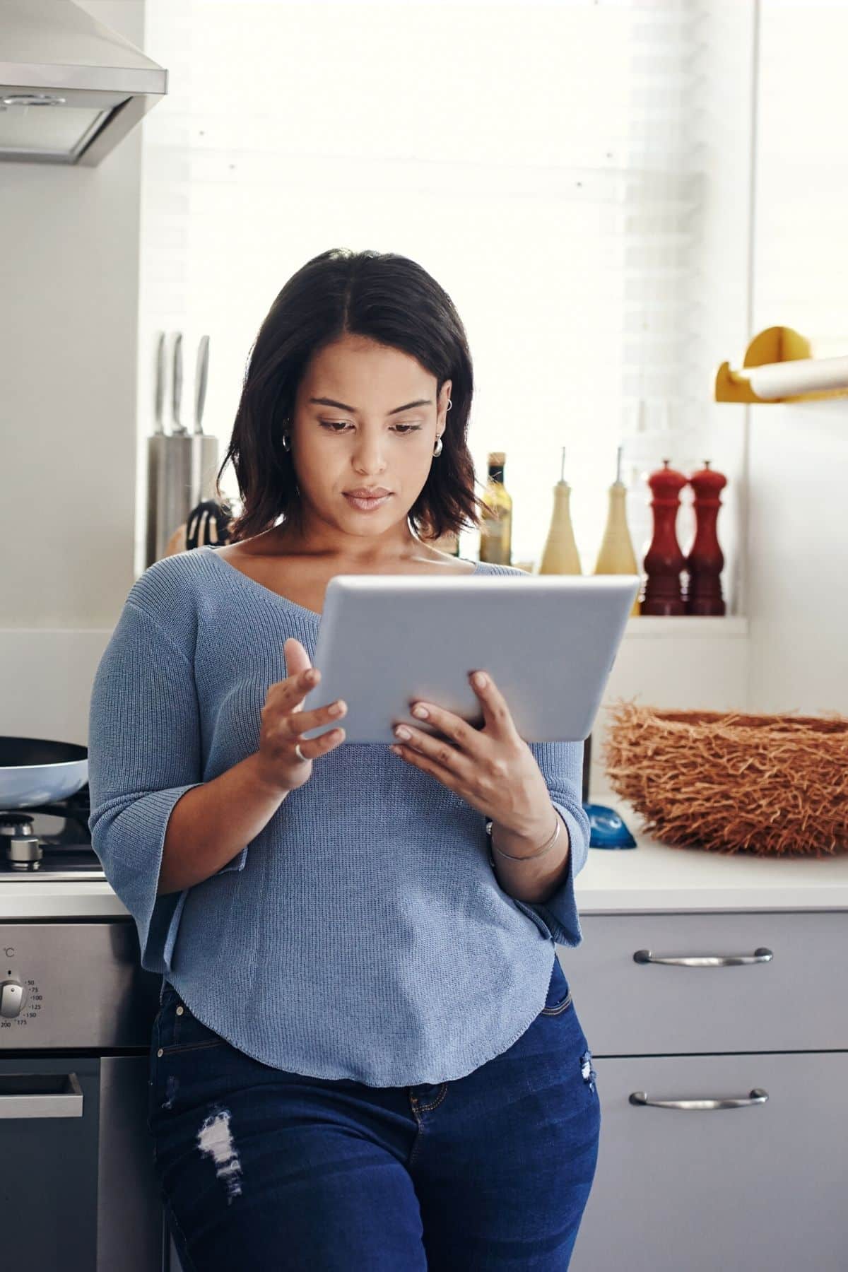 planificación de comidas de mujer en una tableta en su cocina.