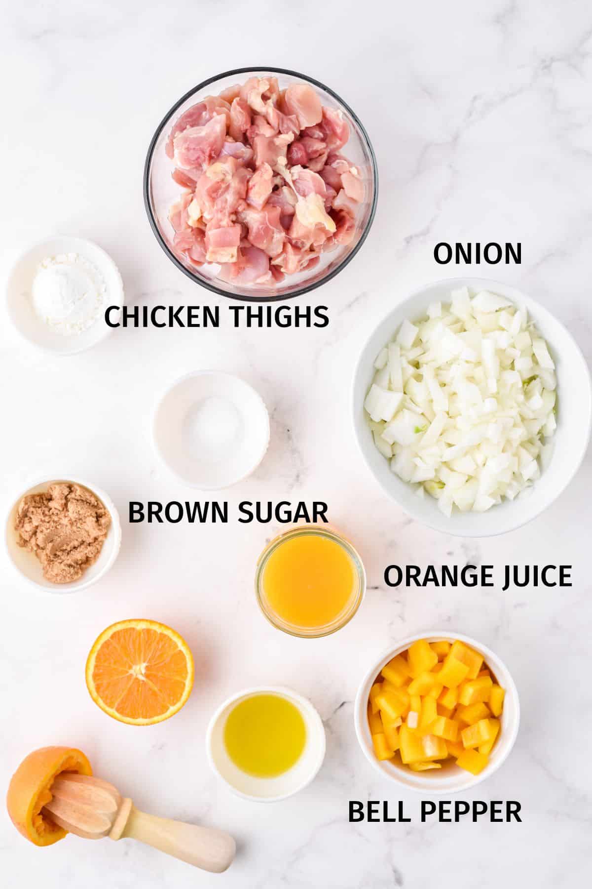 Ingredientes para pollo a la naranja Instant Pot en tazones pequeños sobre una superficie blanca.