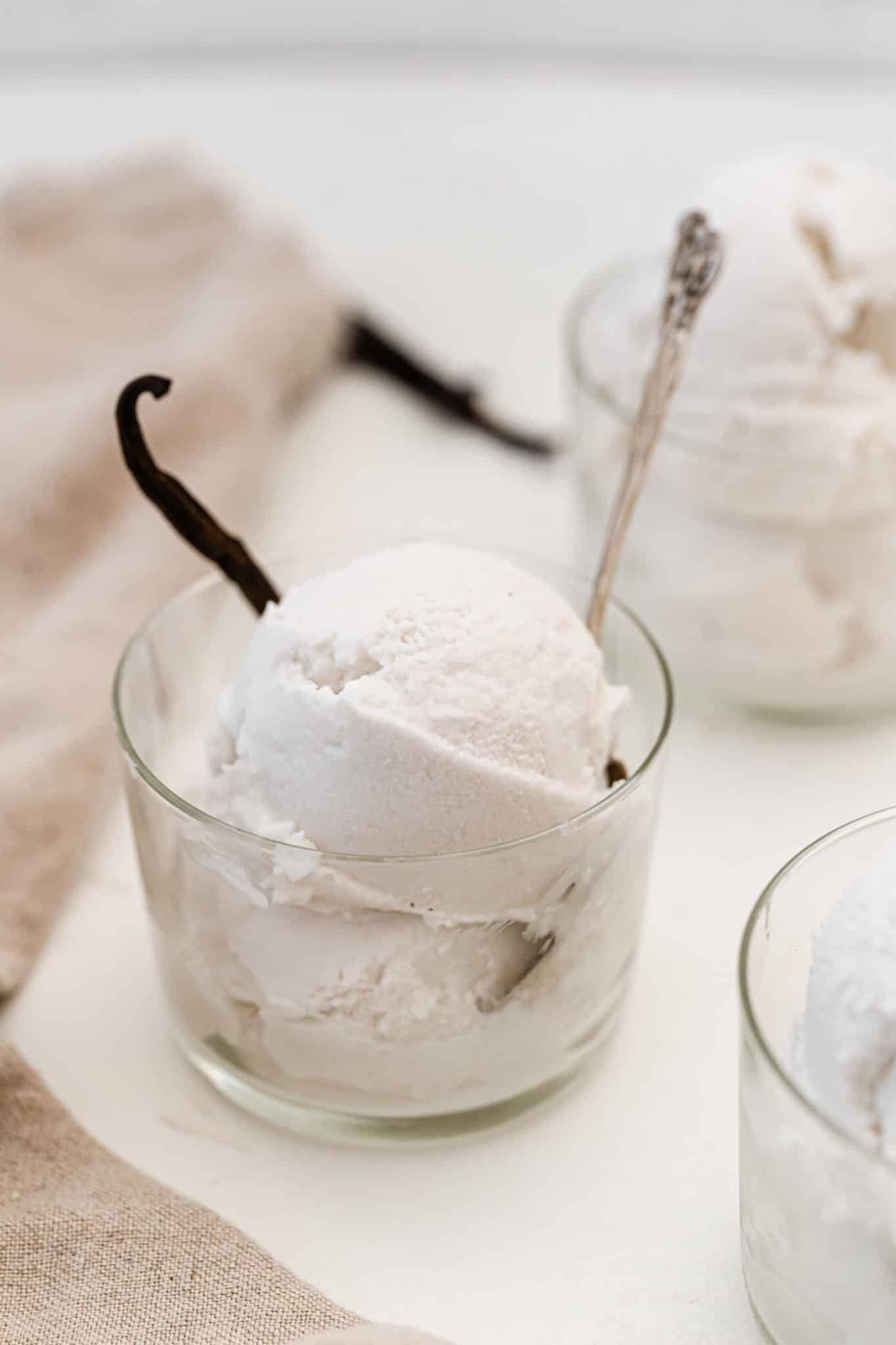 Batidora casera de helado de vainilla con vainilla en un vaso de vidrio.