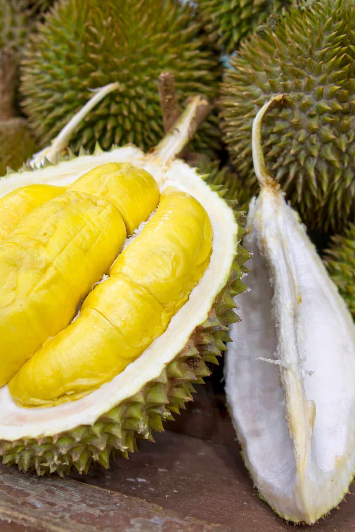 fruta durian en una mesa cortada por la mitad.