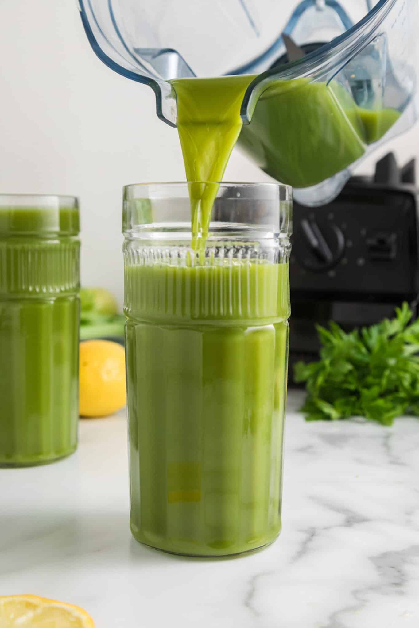 Verter la receta de jugo verde de la licuadora en un vaso alto.